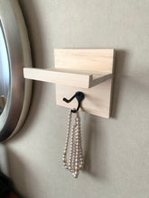 Accent floating shelf with hook made of pine on wall with pearl necklace on hook