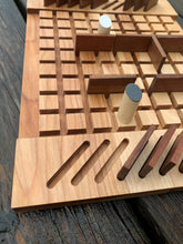 Close-up view of wooden table top game with two pegs and games pieces in play